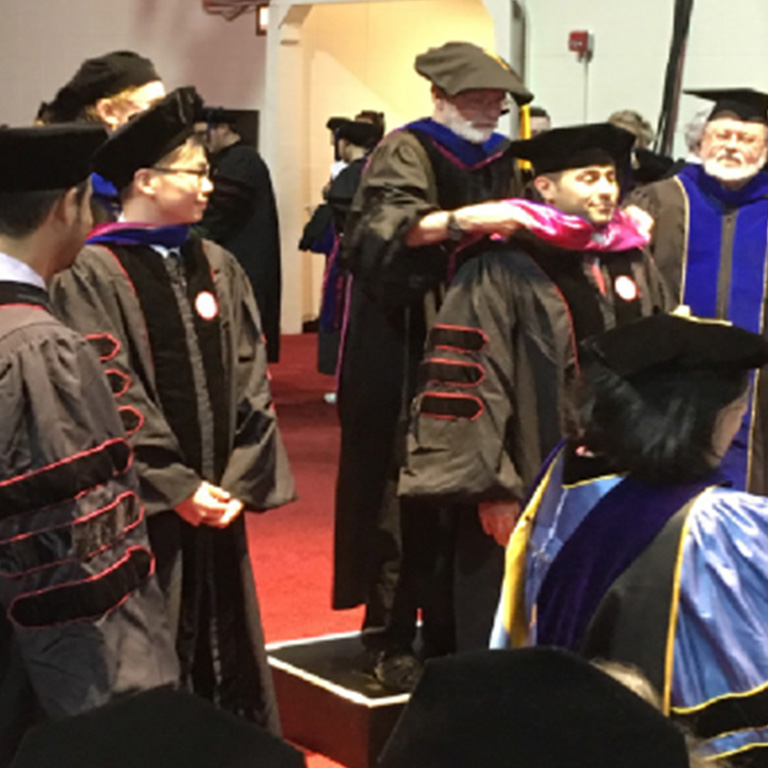 Faculty members get ready for an event in their ceremonial robes.