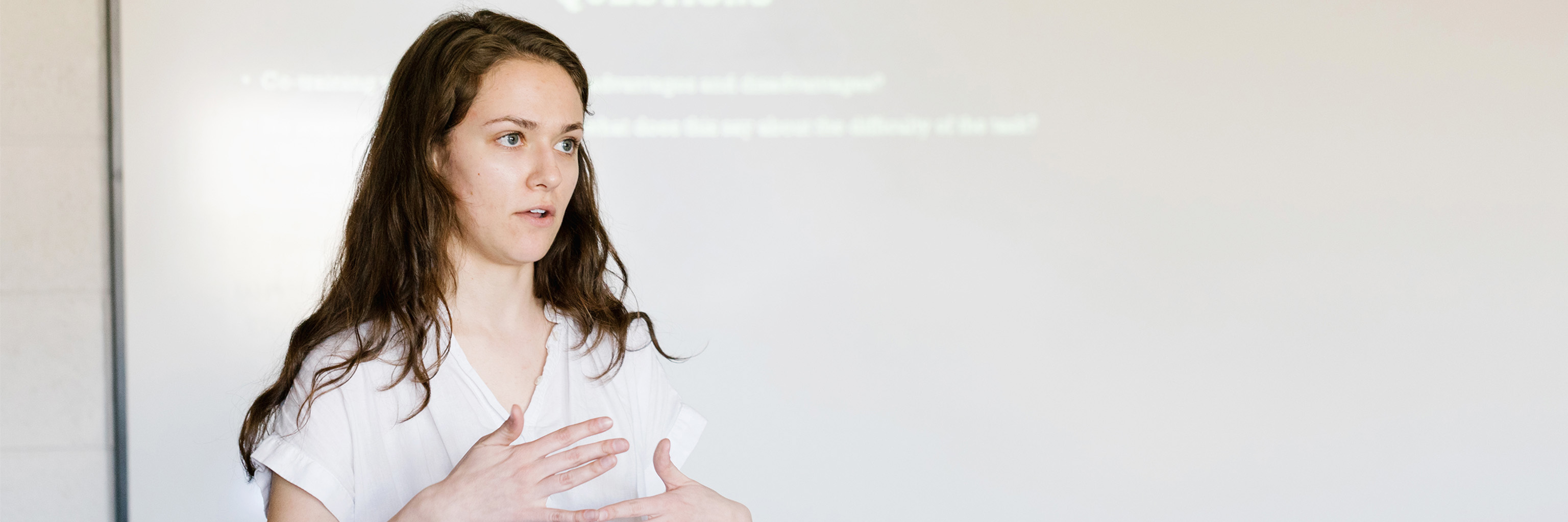 A student gesturing during a presentation.