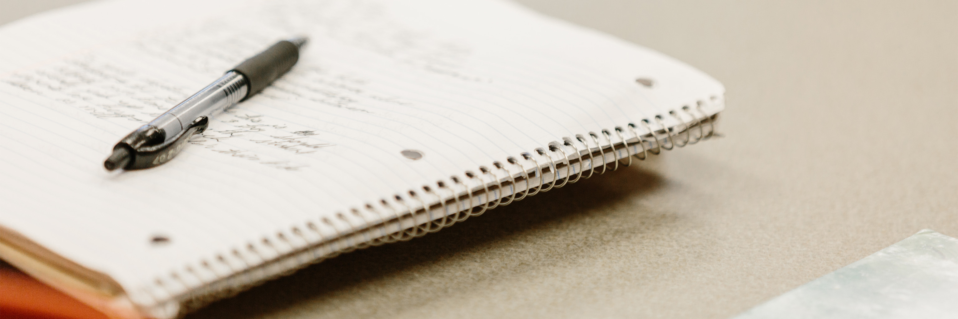 Close-up of a pen sitting on an open notebook.