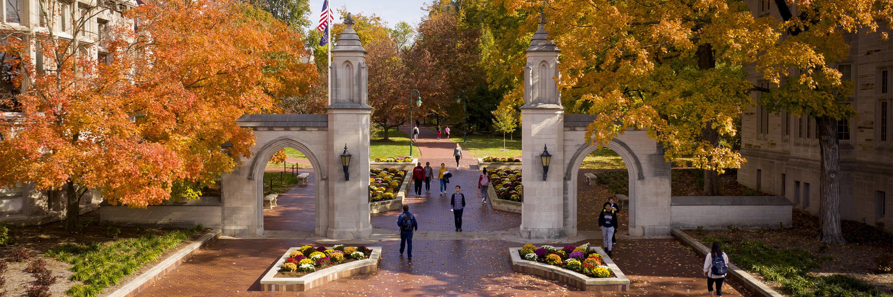 Students walking through the Sample Gates on a fall day at the Indiana University Campus.